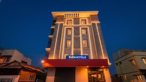 A modern building with a 'fabHOTELS' sign, featuring a prominent entrance and a large garage door. - FabExpress Fen Breeze (Chennai)