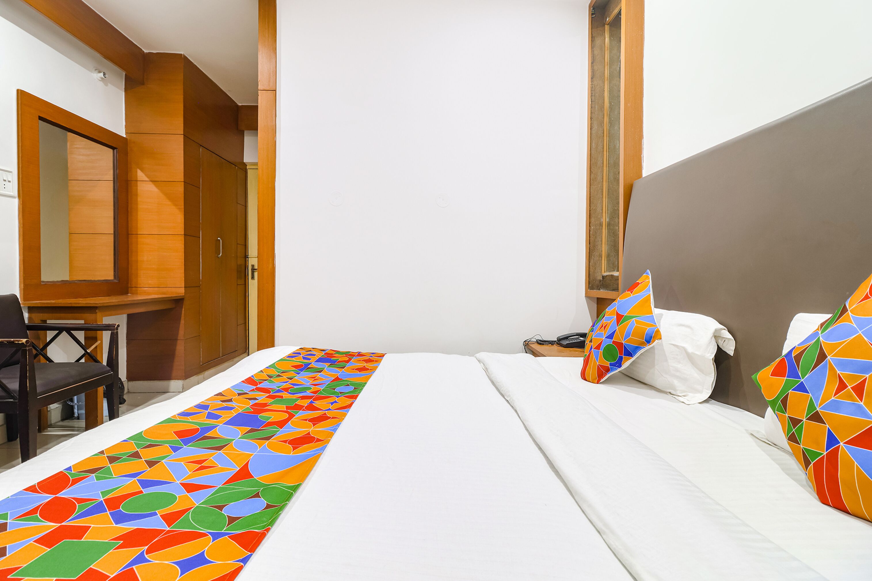 Een hotelkamer met een bed, een bureau en een stoel.