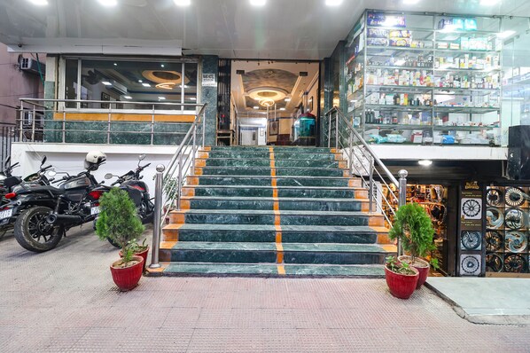 Una escalera que lleva a una tienda con estantes llenos de productos.