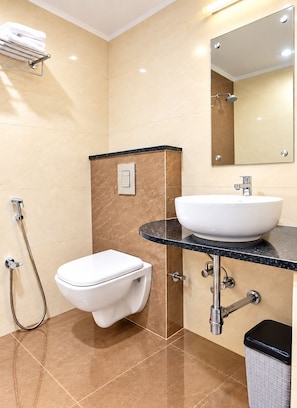 A modern bathroom with a toilet, sink, and shower. - Hotel Magaji Comfort Inn (Bengaluru)