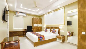 Una habitación de hotel moderna con una cama grande, mesitas de noche, televisión y ventilador de techo.