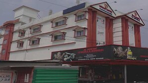 Un immeuble à plusieurs étages, avec une enseigne annonçant un nouveau défi et une boutique de vente de boissons alcoolisées.