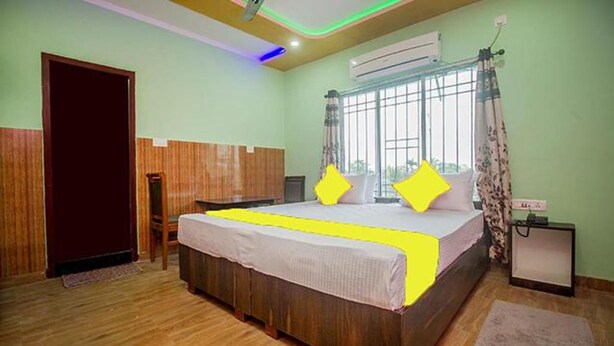 Une chambre avec un lit en bois, une fenêtre avec des rideaux et un appareil de climatisation.