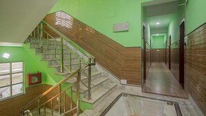 Un escalier avec des marches en bois et des rampes en métal, menant à l’étage supérieur.