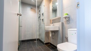 A modern bathroom with a glass-enclosed shower, a white sink, and a toilet. - Capital O 90998 Margo Home (Kota Kinabalu)