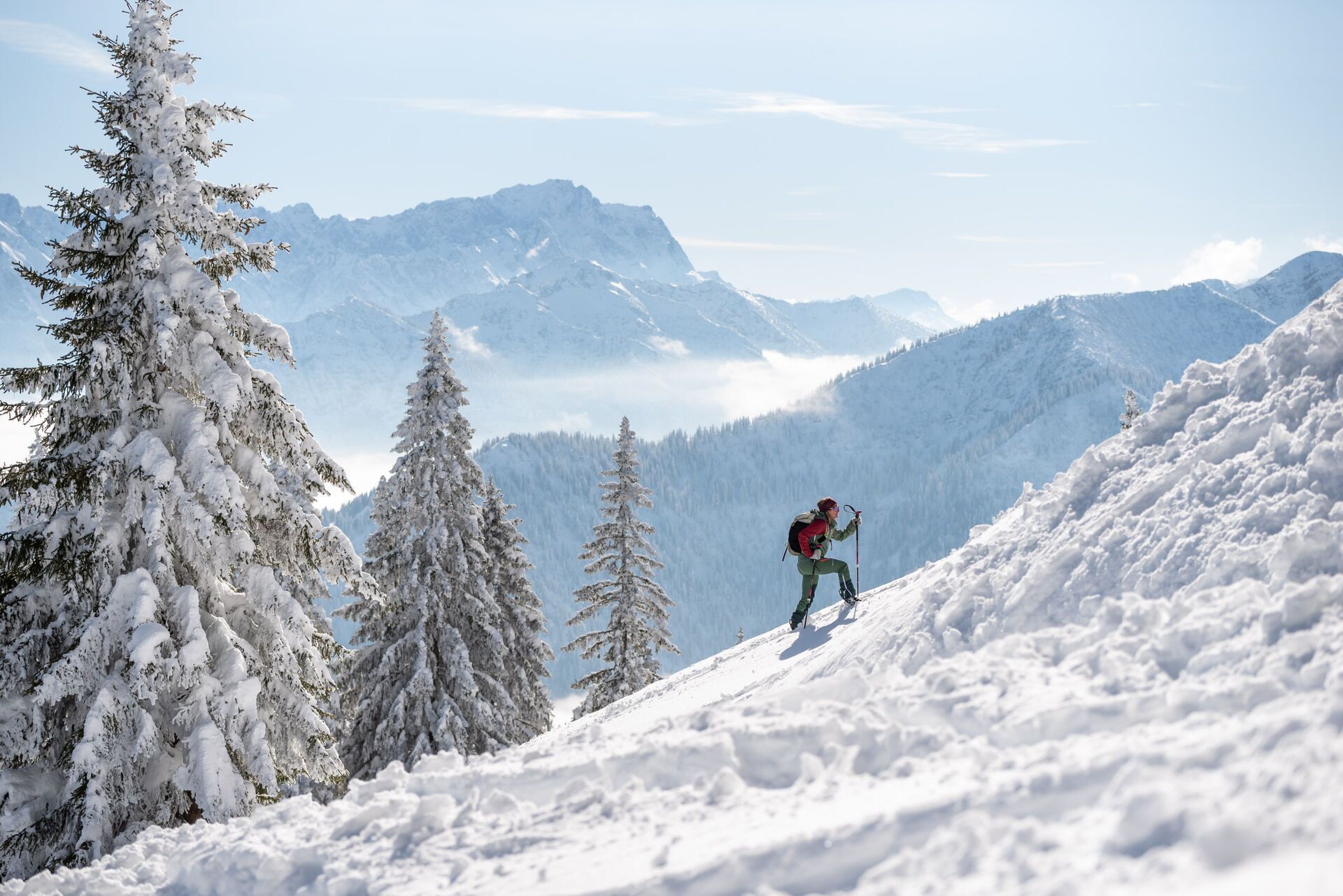A snowy mountain landscape with a person hiking.