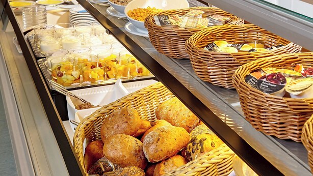 A buffet with various food items including fruits, cheeses, and breads. - Aura Hotel Saulgrub (Saulgrub)