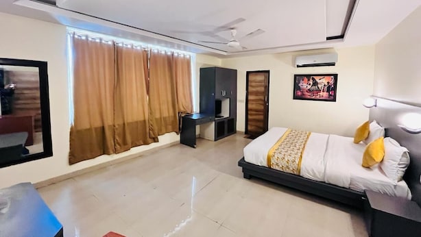 Una habitación de hotel moderna con una cama, un escritorio, un armario y un ventilador de techo.