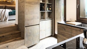 A modern kitchen with wooden cabinetry, a built-in wine rack, and a large window. - Ecobaita del Cacciatore (Incudine)