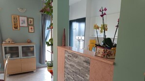 A reception area with a wooden counter, a decorative vase, and framed artwork on the wall. - Villa Hilda (Barban)