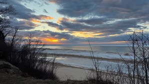 A beach with a view of the ocean and a cloudy sky. - Unique container home retreat near Lake Michigan. Enjoy a peaceful, private setting with a spacious deck, firepit, and ravine views. Close to beaches, wineries, and downtown St. Joseph—perfect for a relaxing Southwest Michigan getaway. (Benton Harbor)