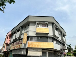 A multi-story building with signs for 'Hotel Golden Mouse' and 'Restoran Low She Fun'.