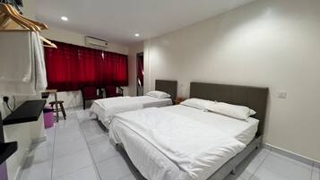 A hotel room with two beds, a desk, a chair, and a red curtain.