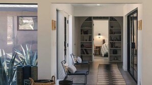 A modern interior with a large bookshelf, a sofa, and a lamp.