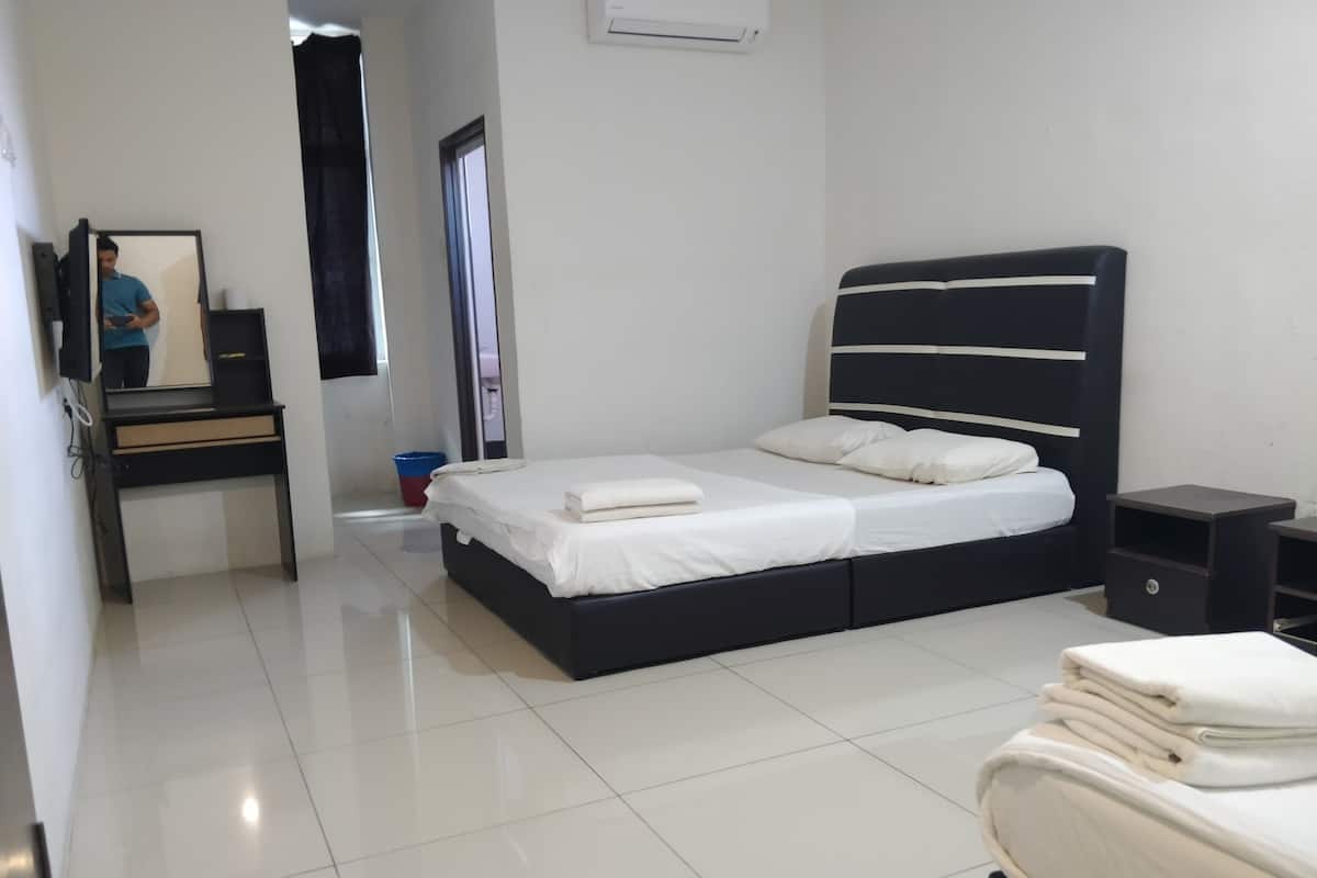 A modern bedroom with a large bed, a desk, and a mirror.
