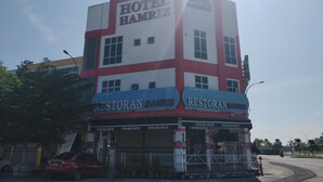 Un hotel de varios pisos con un llamativo letrero que dice 'HOTEL HAMRIZ'.