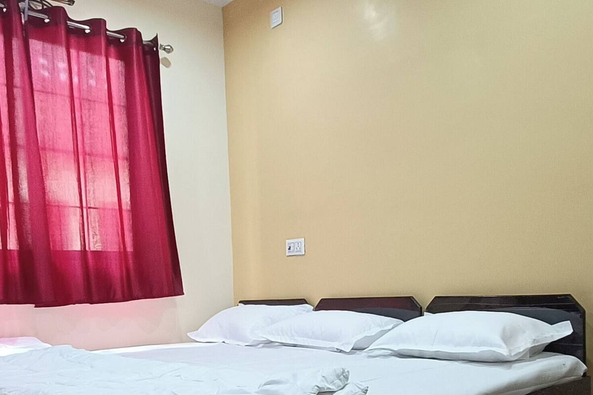 Un dormitorio con cama, ventilador de techo y cortina roja.