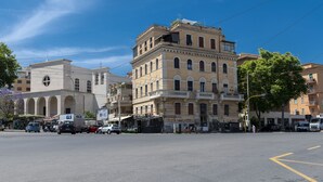 A street view with a building featuring arched windows and a balcony. - Trastevere 900 Liberty (Roma)