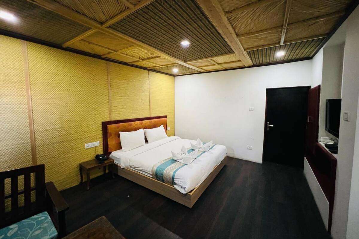 A hotel room with a bed, bedside table, and a television.