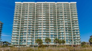 Un hôtel de grande hauteur doté de nombreux balcons et situé en bord de mer.