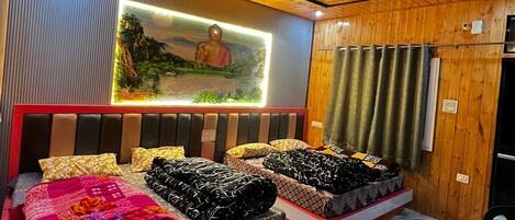 A room with wooden ceiling, a bed with a patterned bedspread, a wall-mounted TV, and a marble floor.
