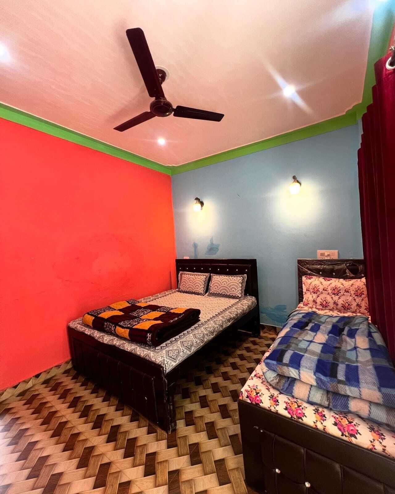 A bedroom with two beds, a ceiling fan, and a patterned floor.
