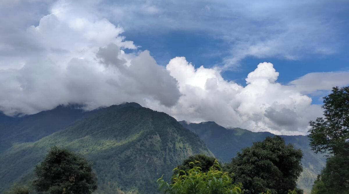 Un paisaje montañoso con vegetación exuberante y cielo despejado.