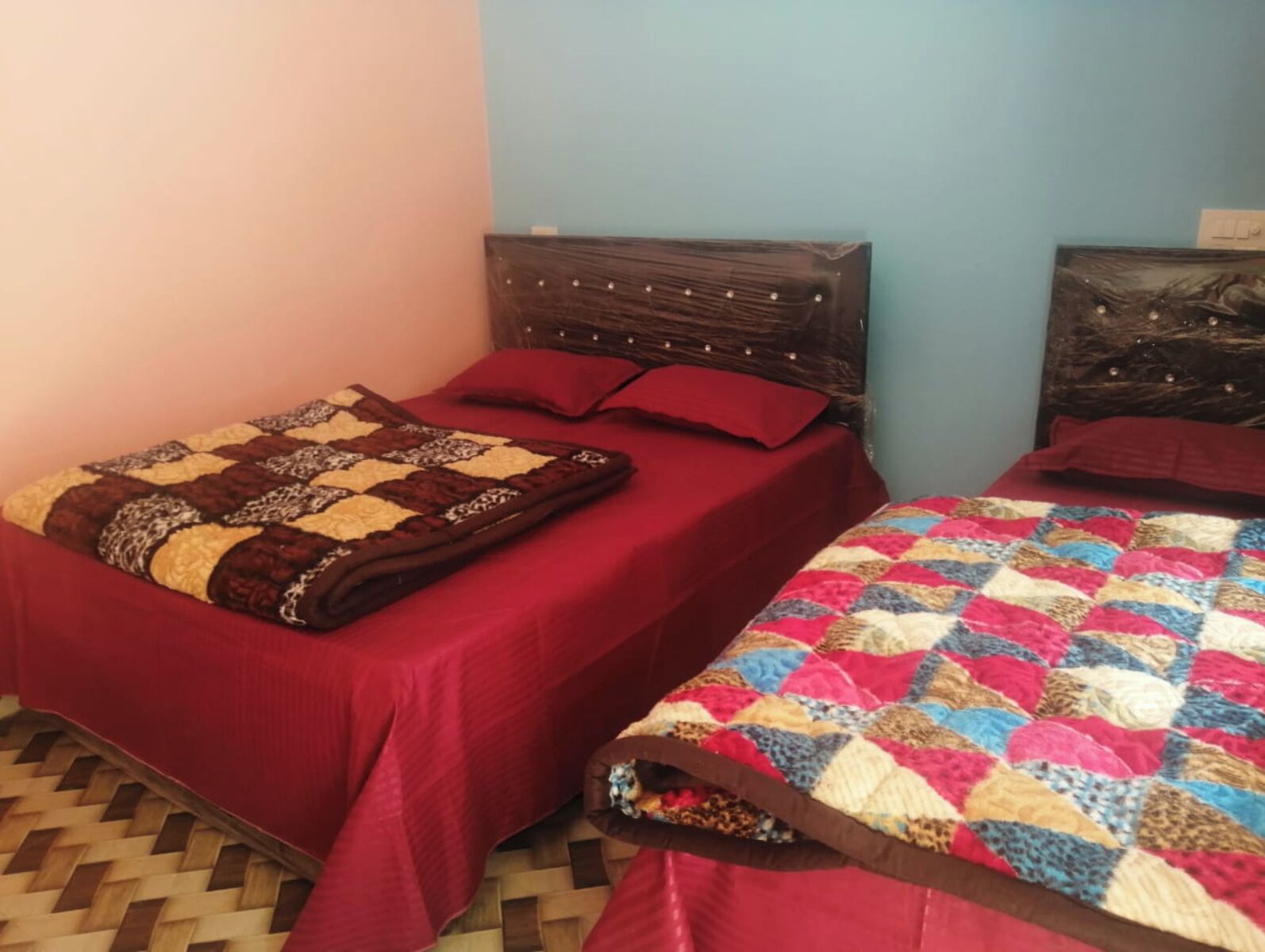 A room with two beds, each with a different style of bedding.