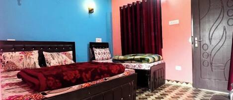 A bedroom with a bed, a desk, a chair, a ceiling fan, and a patterned floor.
