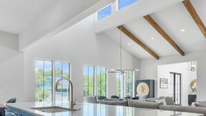 A modern kitchen with a large island, built-in cabinets, and a view of the outdoors. - 4 BR Luxury Home w Private Pool | New Renovation (Isle of Palms)