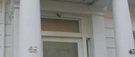 The entrance to Lidos Hotel with a reception desk, a door to the left, and the number 45 on the columns.