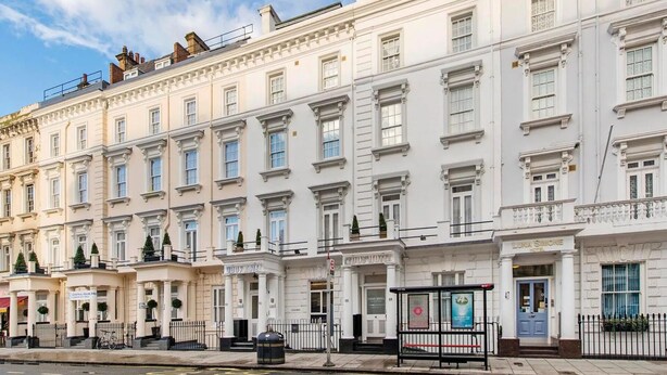 A row of white, classic-style hotels with uniform facades, large windows, and symmetrical architecture. - Lidos Hotel (London)