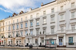 A row of white, classic-style hotels with uniform facades, large windows, and symmetrical architecture. - Lidos Hotel (London)
