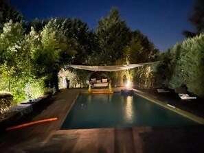 Relax by the pool surrounded by lush greenery and comfortable lounge seating.