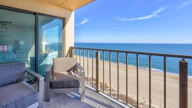 Een balkon met uitzicht op het strand en de oceaan.