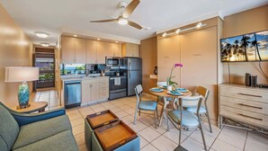 Une cuisine moderne avec un coin repas, un ventilateur de plafond et une vue sur les palmiers.