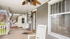 A covered porch with a wooden floor, a white rocking chair, and a ceiling fan. - Historic/Renovated home steps to Notre Dame(103) (South Bend)