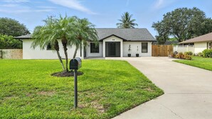 A single-story house with a front yard, mailbox, and a number "98" on the door. - Sunny Pool Retreat, Pet-Friendly Near Beaches (Naples)