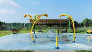 An outdoor playground with colorful climbing structures and a covered seating area. - Safari Tent A at Eden Reserve - Near Ark (Williamstown)