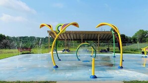 An outdoor playground with colorful climbing structures and a covered seating area. - Safari Tent D at Eden Reserve - Near Ark (Williamstown)