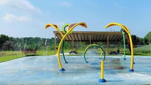 An outdoor playground with colorful climbing structures and a covered seating area. - Safari Tent G at Eden Reserve - Near Ark (Williamstown)