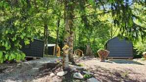 A forested area with several cabins, a wildlife sign, and a stack of firewood. - Property of Big Foot Roscoe, NY (Roscoe)