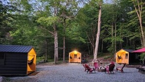 A campsite with two wooden cabins, a gravel area, and a picnic table. - Property of Big Foot Roscoe, NY (Roscoe)