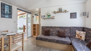 Un salon confortable avec un canapé, une table à manger et des chaises, ainsi qu’un petit coin cuisine.