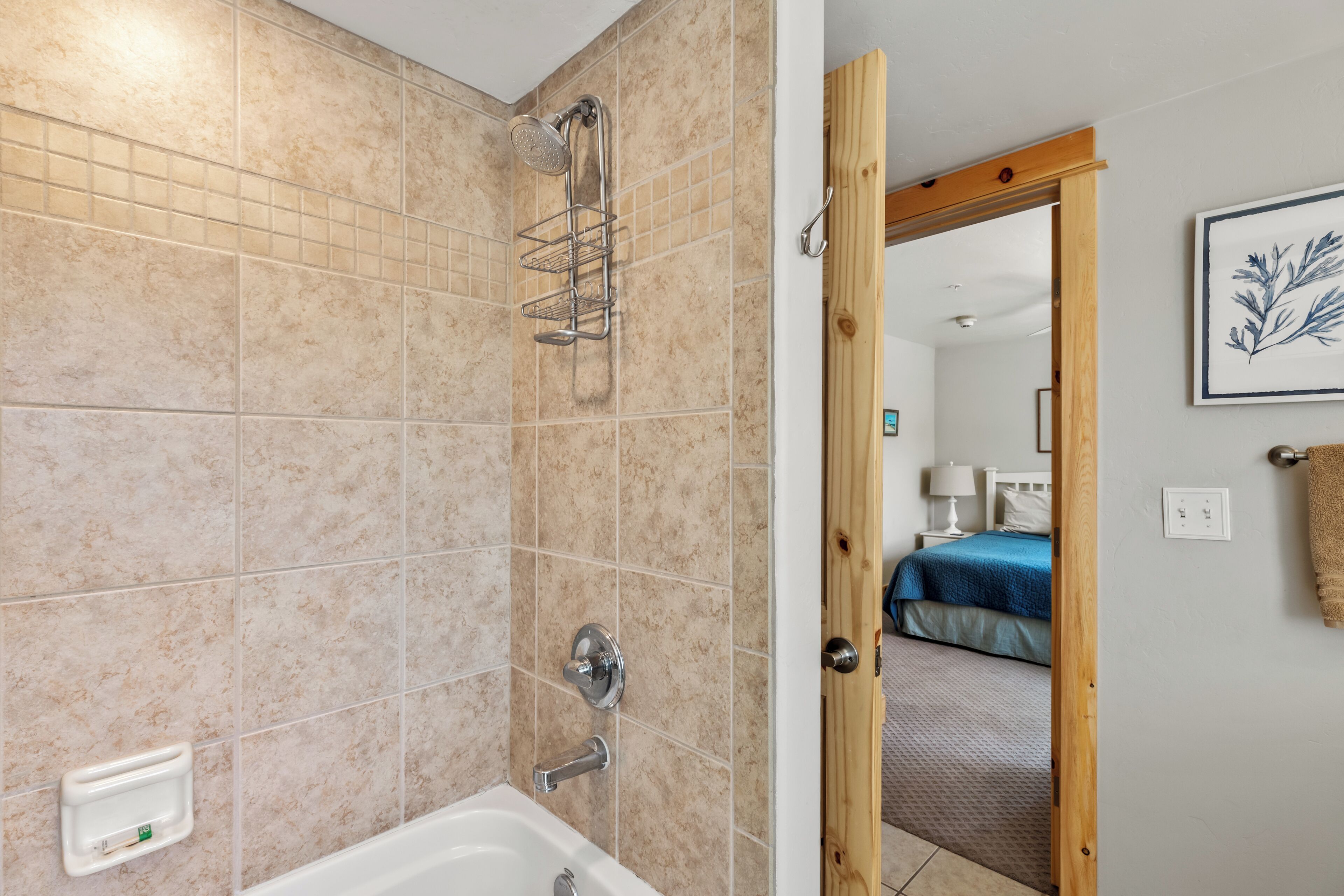 A bathroom with beige tiles, a shower, and a bathtub.
