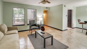 A living room with a sofa, a coffee table, a chair, and a ceiling fan. - 3 Mi to Dtwn Dallas: Condo w/ Walkable Location! (Dallas)