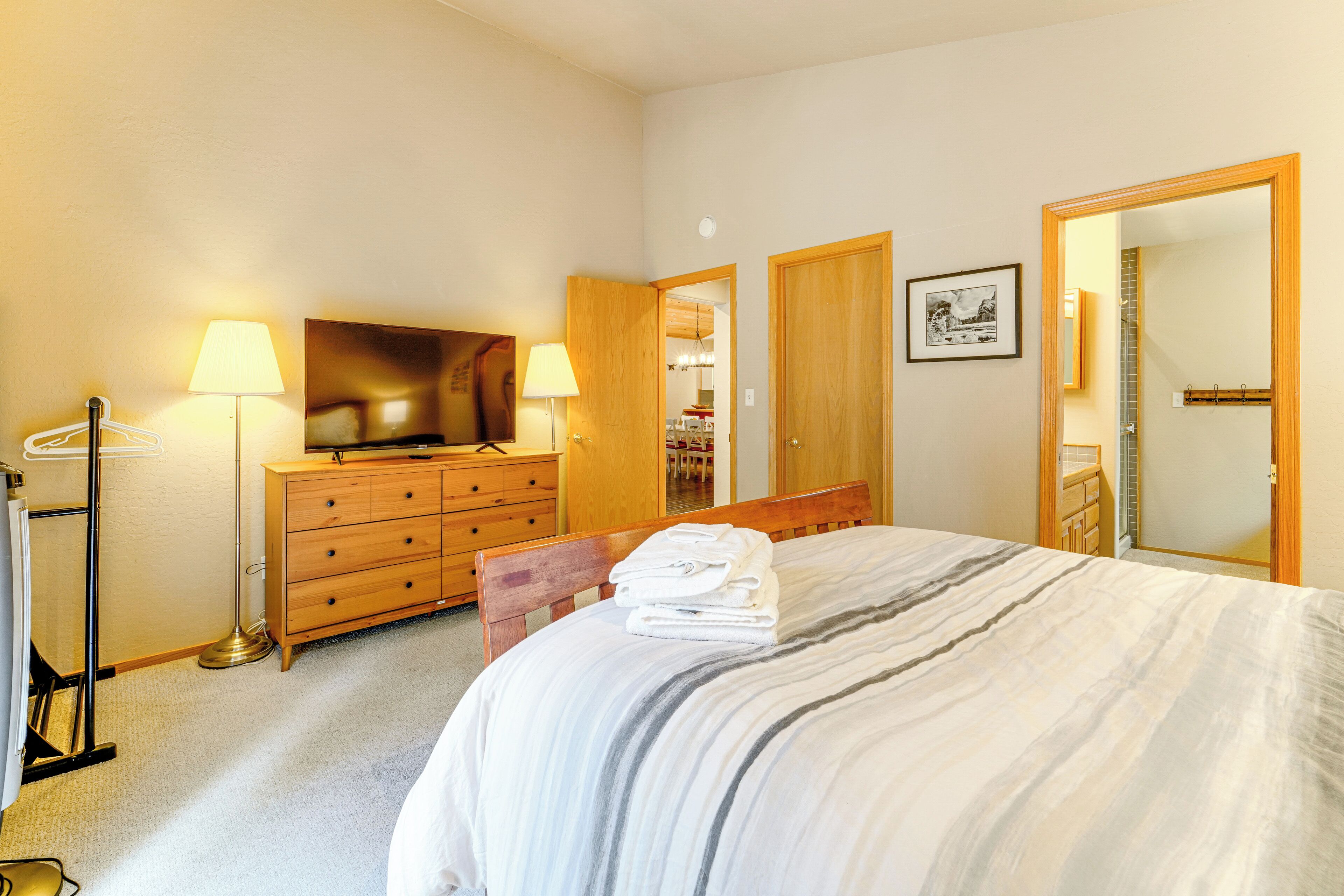 Ein Hotelzimmer mit Bett, Schminktisch, Fernseher und Spiegel.