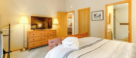 Ein Hotelzimmer mit Bett, Schminktisch, Fernseher und Spiegel.