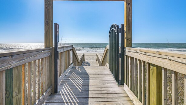 A wooden boardwalk leading to a beach with a clear sky. - Pool & Ocean View: Myrtle Beach Resort Condo! (Myrtle Beach)