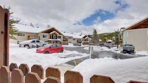 Un barrio residencial con casas, coches aparcados y suelo cubierto de nieve.